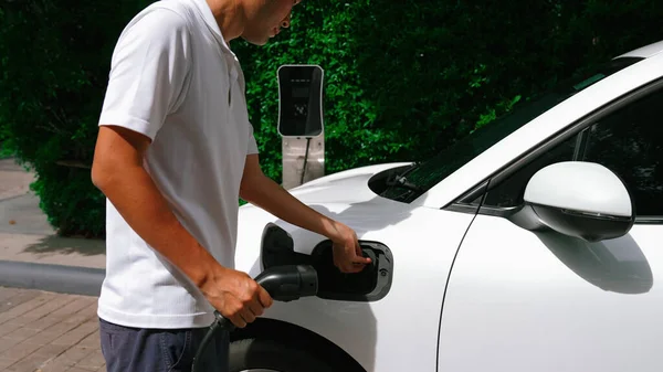 Postępowy Człowiek Instaluje Wtyczkę Kablową Swojego Pojazdu Elektrycznego Samochód Stacji — Zdjęcie stockowe