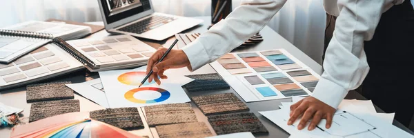 Interior architect designer at table designing hand choosing color samples with architecture software on laptop screen. Modern house renovation and interior color selection design concept. Insight