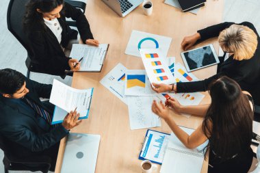 İş adamları grup toplantısı ofiste yukarıdan çekildi. İş kadınları, iş adamları ve ofis çalışanları toplantı masasında proje planlama belgeleriyle takım konferansında çalışıyorlar. Jivy