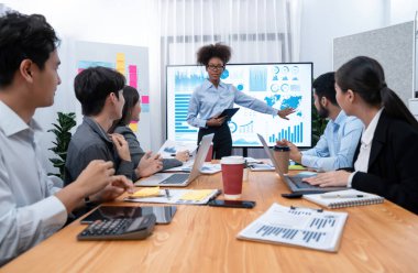 Genç Afrikalı iş kadını modern toplantıda TV ekranında veri analizi paneli sunuyor. Bir grup iş adamıyla konferans odasında iş sunumu. Uyum