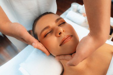 Kafkasyalı kadın stres önleyici kafa masajından ve lüks tatil beldesi ya da otel spa salonundaki modern ışık ortamında yüz güzelliği eğlencelerini şımartmaktan hoşlanıyor. Sessiz.