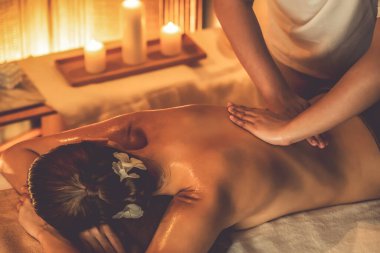 Beyaz kadın müşteri stres önleyici spa masajının keyfini çıkarıyor ve lüks otel ya da otelde sıcak mum ışığında güzellik teniyle eğleniyor. Sessiz.