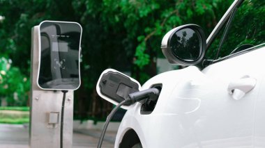 Elektrikli araba parkı ve şarj istasyonunun yanında şarj edilen enerji konseptinin sürdürülebilirliği. Çevresel koruma için yenilenebilir enerji tarafından kullanılan elektrikli araç.