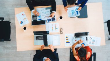 İş adamları grup toplantısı ofiste yukarıdan çekildi. İş kadınları, iş adamları ve ofis çalışanları toplantı masasında proje planlama belgeleriyle takım konferansında çalışıyorlar. Jivy