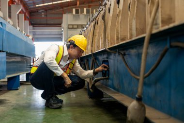 Mühendis ya da ustabaşı müfettiş makine üretim hattında profesyonel teftiş yapıyor. Makine güvenliği ve kalite kontrol süreci ile fabrika konseptinde mühendislik üretimi. Örnek gösteriliyor