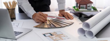 Çalışma masasının iç mimar tasarımcısı evin iç planlarını tasarlıyor ve ruh hali kurulu örneklerini seçiyor. Ev yenileme ya da tasarım konsepti için yaratıcı el çizimi planı. İçgörü