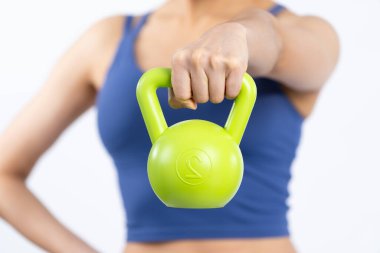 Bulanık arka planda ağırlık kaldırma egzersizi yapan enerjik, enerjik bir kadın tarafından tutulan kettlebell 'e odaklan. Vücut egzersizi olarak atletik kadın gücü ve dayanıklılık antrenmanı..