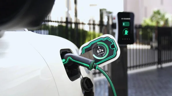 Electric car recharge with EV charger at futuristic car park utilization of charging station display battery status hologram for rechargeable EV car using alternative and sustainable energy.Peruse