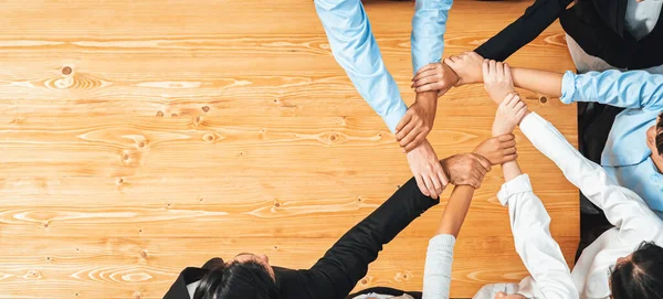 stock image Multicultural business people holding hand together in circle. Unity teamwork in office business workplace. Diverse ethnic office worker engaged in team building. Panorama top view. Meticulous