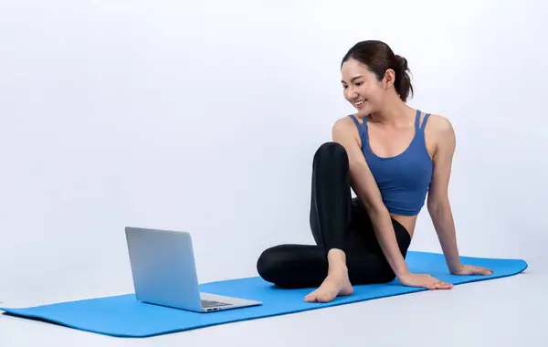 年轻的亚洲女子穿着运动服 在运动前根据网上视频的指示进行伸展运动 在与世隔绝的背景下 与健康的女运动员一起进行体育锻炼 精力充沛的 — 图库照片