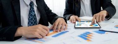 Grup toplantısındaki iş adamları resmi kıyafet paylaşımı fikrine sahipler. Şirketin yaratıcı çalışma alanındaki kar raporunu tartışıyorlar. Grup toplantısı masasında yakın çekim yapmak için. Konuşma .