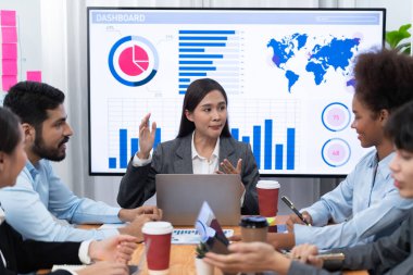 Genç Asyalı iş kadını modern toplantıda TV ekranında veri analizi paneli sunuyor. Bir grup iş adamıyla konferans odasında iş sunumu. Uyum