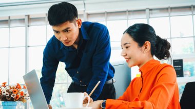 İki iş adamı toplantı odasında proje stratejisi hakkında konuşuyor. İş adamı, iş yerinde iş arkadaşlarıyla proje planlamasını tartışırken aynı zamanda mali raporla ilgili sohbet ve tavsiyelerde bulunuyor. Jivy