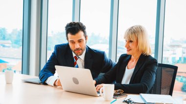 İki iş adamı toplantı odasında proje stratejisi hakkında konuşuyor. İş adamı, iş yerinde iş arkadaşlarıyla proje planlamasını tartışırken aynı zamanda mali raporla ilgili sohbet ve tavsiyelerde bulunuyor. Jivy