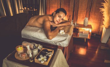 Beyaz kadın müşteri stres önleyici spa masajının keyfini çıkarıyor ve lüks otel ya da otelde sıcak mum ışığında güzellik teniyle eğleniyor. Sessiz.