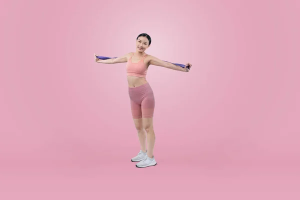穿着运动服的精力充沛的女人伸展着抵抗运动乐队 年轻的亚洲女运动员力量和耐力训练课程在孤立背景下的日常锻炼理念 — 图库照片