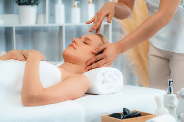 Kafkasyalı kadın stres önleyici kafa masajından ve lüks tatil beldesi ya da otel spa salonundaki modern ışık ortamında yüz güzelliği eğlencelerini şımartmaktan hoşlanıyor. Sessiz.