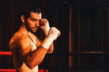 Üstsüz boksör pozu veren, beyaz boksör yumruğunu yumruklayıp kameranın önüne geçiyor, agresif duruşunu takınıyor ve boks ringinde dövüşmeye hazır. Impetus