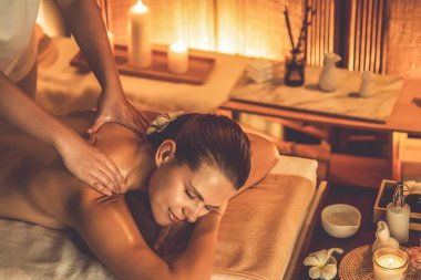 Beyaz kadın müşteri stres önleyici spa masajının keyfini çıkarıyor ve lüks otel ya da otelde sıcak mum ışığında güzellik teniyle eğleniyor. Sessiz.