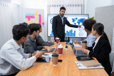 Pazarlama stratejisi için modern toplantıda veri analizi paneli ekranında sunan bir işadamı. Bir grup iş adamıyla konferans odasında iş sunumu. Uyum