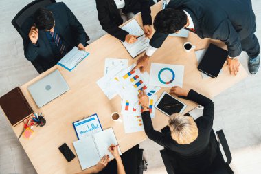 İş adamları grup toplantısı ofiste yukarıdan çekildi. İş kadınları, iş adamları ve ofis çalışanları toplantı masasında proje planlama belgeleriyle takım konferansında çalışıyorlar. Jivy