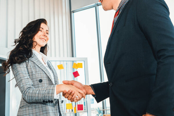 Business people handshake in corporate office showing professional agreement on a financial deal contract. Jivy