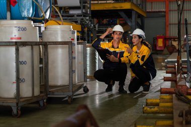 İki fabrika işçisi veya mühendis, kimya fabrikası, kimya fabrikası işyeri ve endüstriyel meslek konseptinde makine veya prosedür üzerinde profesyonel teftiş yürütüyor. Örnek gösteriliyor