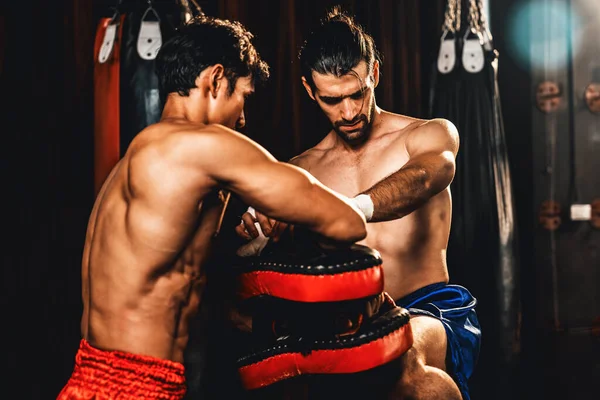アジア人と白人ムエタイのボクサーは激しいボクシングトレーニングセッションで膝の攻撃を放ち スプリングトレーナーに膝の打撃を与え ムエタイのボクシング技術とスキルを紹介します インペトゥス — ストック写真