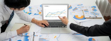 Grup toplantısındaki iş adamları resmi kıyafet paylaşımı fikrine sahipler. Şirketin yaratıcı çalışma alanındaki kar raporunu tartışıyorlar. Grup toplantısı masasında yakın çekim yapmak için. Konuşma .