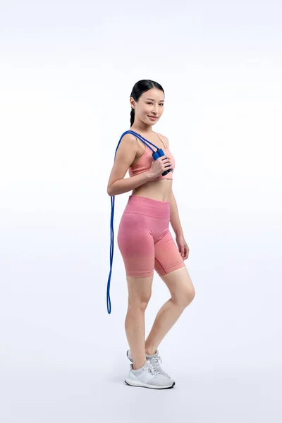 スポーツウェアの若いエネルギッシュなアジアの女性は 孤立した背景に撮影されたスタジオの肖像画をジャンプまたはスキップします カーディオエクササイズツールと健康的なボディケアライフスタイル ヴィゴーラス — ストック写真