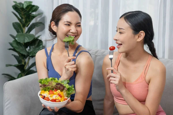 サラダボールを保持するスポーツウェアの若いスポーティなアジアの女性は フルーツと野菜の活気に満ちています 自然で若々しく バランスの取れた栄養と家庭での運動で体のライフスタイルにフィットします ヴィゴーラス — ストック写真