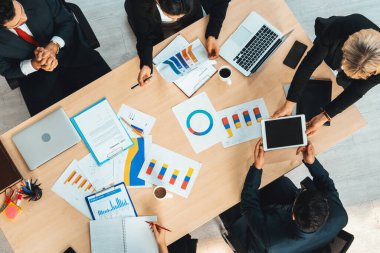 İş adamları grup toplantısı ofiste yukarıdan çekildi. İş kadınları, iş adamları ve ofis çalışanları toplantı masasında proje planlama belgeleriyle takım konferansında çalışıyorlar. Jivy