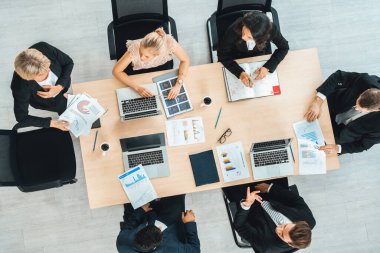İş adamları grup toplantısı ofiste yukarıdan çekildi. İş kadınları, iş adamları ve ofis çalışanları toplantı masasında proje planlama belgeleriyle takım konferansında çalışıyorlar. Jivy