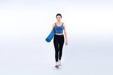 Spor kıyafetleriyle spor minderiyle genç ve çekici Asyalı kadın portresi. Sağlıklı egzersiz ve rutin yaşam tarzı konsepti. Stüdyo çekimi izole edildi. Kuvvetli