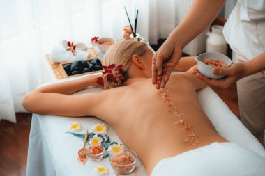 Lüks spa salonlarında sıcak mum ışığında cilt bakımı yaptıran kadın müşteri. Sağlık Spa vücut fırçasında tuz temizleme güzellik tedavisi. Sessiz.