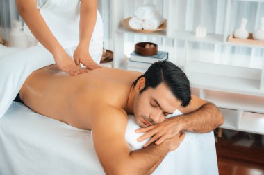 Kafkas erkek müşteri stres önleyici spa masajının keyfini çıkarıyor ve lüks otel veya oteldeki gündüz açık hava ortamında güzellik derisi eğlencesi ile şımartıyor. Sessiz.