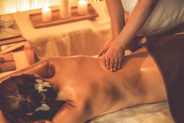 Beyaz kadın müşteri stres önleyici spa masajının keyfini çıkarıyor ve lüks otel ya da otelde sıcak mum ışığında güzellik teniyle eğleniyor. Sessiz.
