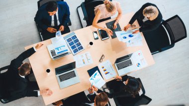 İş adamları grup toplantısı ofiste yukarıdan çekildi. İş kadınları, iş adamları ve ofis çalışanları toplantı masasında proje planlama belgeleriyle takım konferansında çalışıyorlar. Jivy