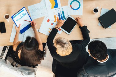 İş adamları grup toplantısı ofiste yukarıdan çekildi. İş kadınları, iş adamları ve ofis çalışanları toplantı masasında proje planlama belgeleriyle takım konferansında çalışıyorlar. Jivy