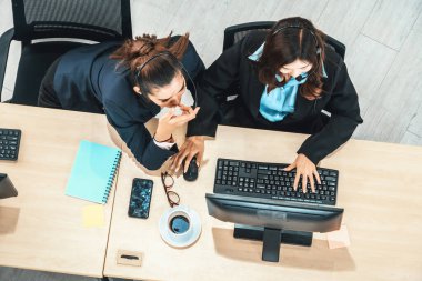 Ofiste bilgisayar başında çalışan, kulaklık takan iş adamları. Jivy