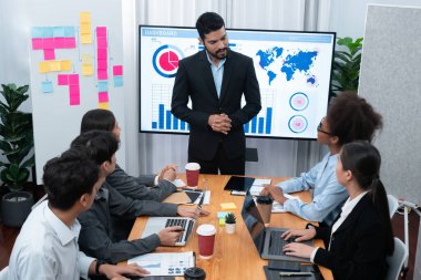 Pazarlama stratejisi için modern toplantıda veri analizi paneli ekranında sunan bir işadamı. Bir grup iş adamıyla konferans odasında iş sunumu. Uyum