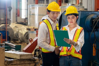 Profesyonel kalite kontrol müfettişi fabrikadaki makine ve imalat sürecinde güvenlik denetimi yapıyor. Ağır sanayi tesislerinde işlem optimizasyonunu denetleyen mühendisler. Örnek gösteriliyor