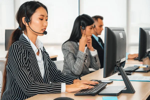 Business people wearing headset working in office to support remote customer or colleague. Call center, telemarketing, customer support agent provide service on telephone video conference call. Jivy