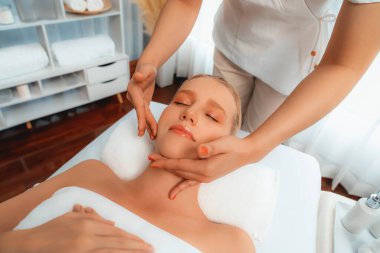 Kafkasyalı kadın stres önleyici kafa masajından ve lüks tatil beldesi ya da otel spa salonundaki modern ışık ortamında yüz güzelliği eğlencelerini şımartmaktan hoşlanıyor. Sessiz.