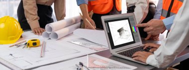 Mühendis ve mimar birlikte çalışarak ayrıntılı bir dijital iç mimari ya da yapı tasarımı için dizüstü bilgisayar kullanarak beyin fırtınası yapıyor ve tasarım yapıyor. İçgörü