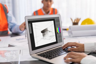 Mühendis ve mimar birlikte çalışarak ayrıntılı bir dijital iç mimari ya da yapı tasarımı için dizüstü bilgisayar kullanarak beyin fırtınası yapıyor ve tasarım yapıyor. İçgörü