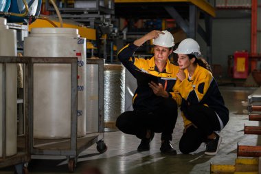 İki fabrika işçisi veya mühendis, kimya fabrikası, kimya fabrikası işyeri ve endüstriyel meslek konseptinde makine veya prosedür üzerinde profesyonel teftiş yürütüyor. Örnek gösteriliyor