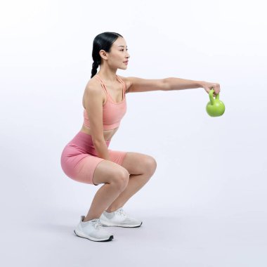 Dinç, enerjik bir kadın izole edilmiş arka planda ağırlık kaldırma egzersizi yapıyor. Genç atletik Asyalı kadın dayanıklılığı ve dayanıklılık eğitimi rutin vücut egzersizi..