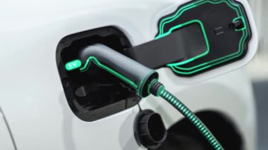 Elektrikli araba şarj istasyonuna bağlandı EV şarj kablosuyla pili şarj etmek için. Yenilikçi alternatif enerji ve fütürist akıllı elektrikli araba şarj aleti. İnceleyin