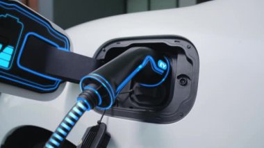 Fütürist EV şarj cihazıyla elektrikli araba şarj istasyonundan şarj oluyor. EV arabaların son teknoloji gelişimi ve sürdürülebilir enerji için akıllı ev yenilenebilir enerji altyapısı. İnceleyin